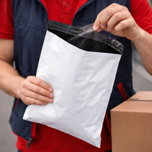 Bolsas de mensajería blancas con interior negro y solapa adhesiva manipuladas por repartidor